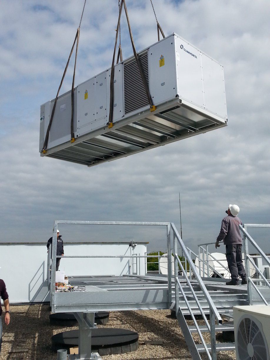 Pose d'une CTA sur une passerelle en acier galvanisé