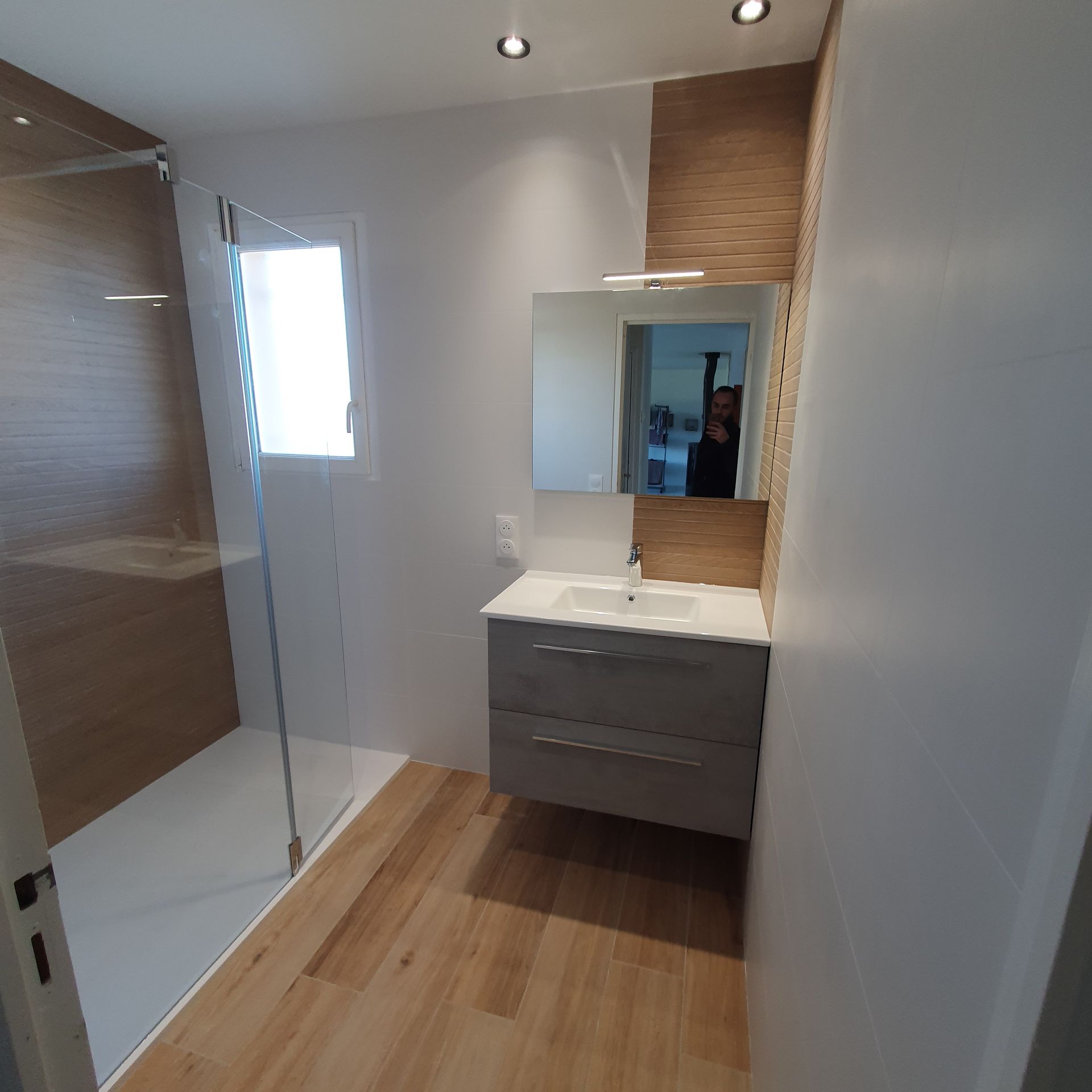 Une douche à l'italienne avec un lavabo suspendu.