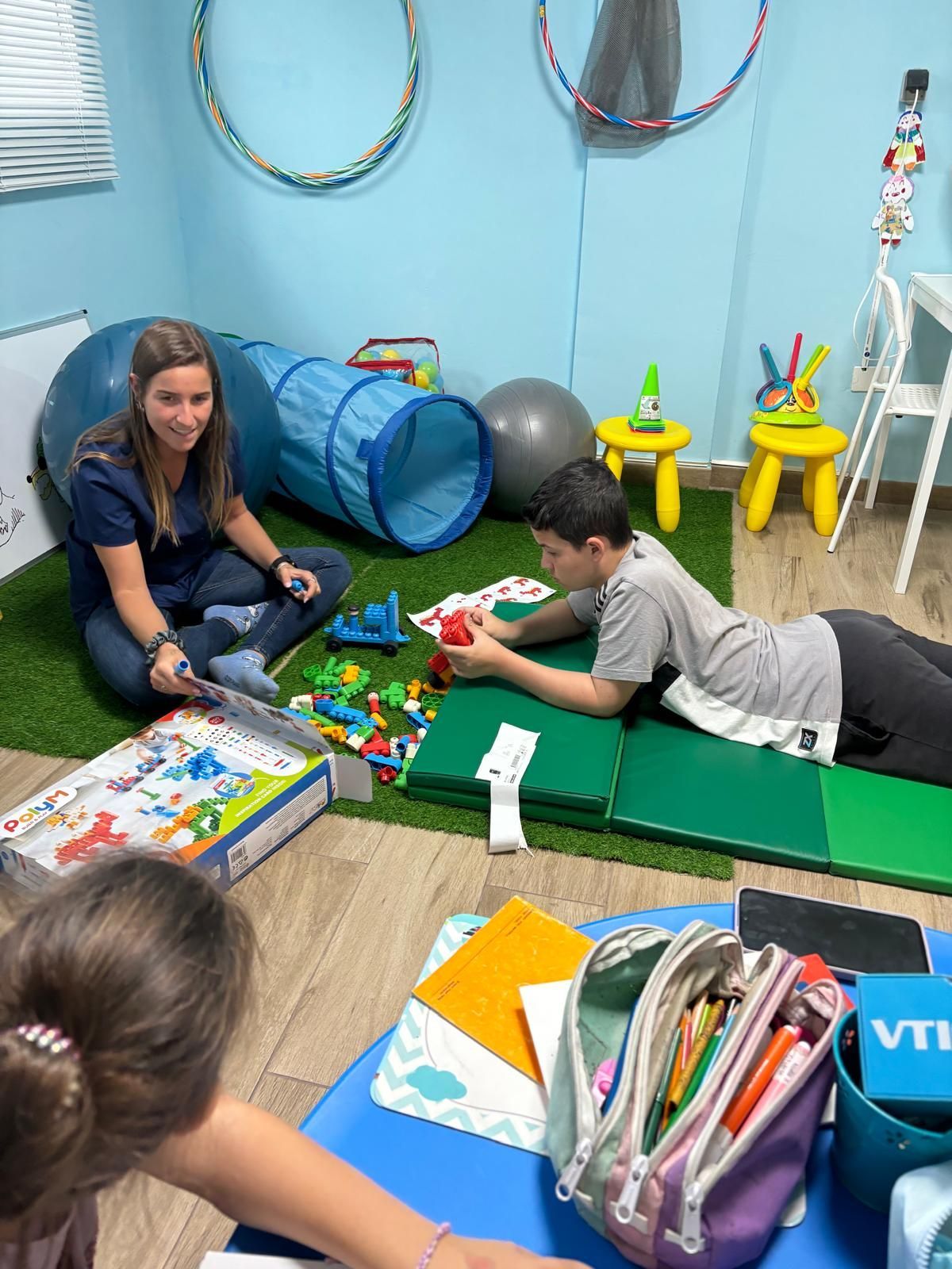 Una mujer y un niño están jugando con juguetes en una habitación.