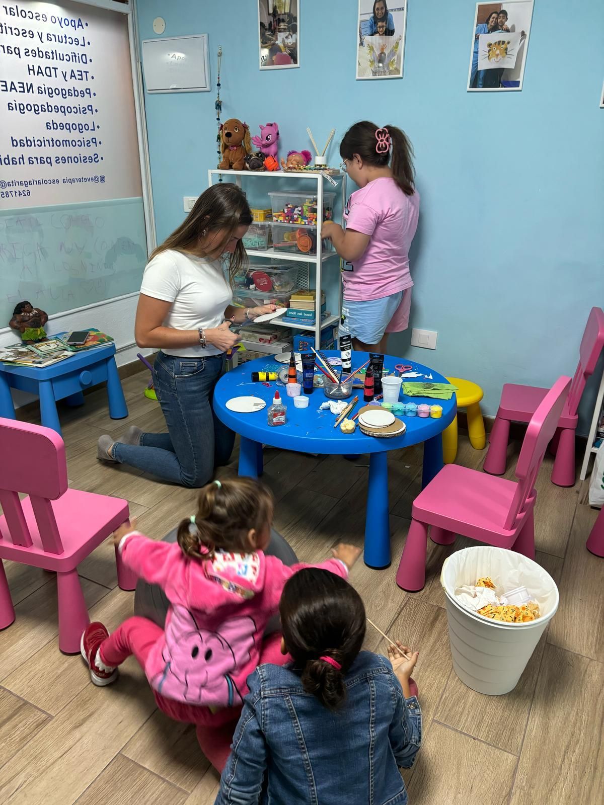Un grupo de niños están sentados alrededor de una mesa en una habitación.