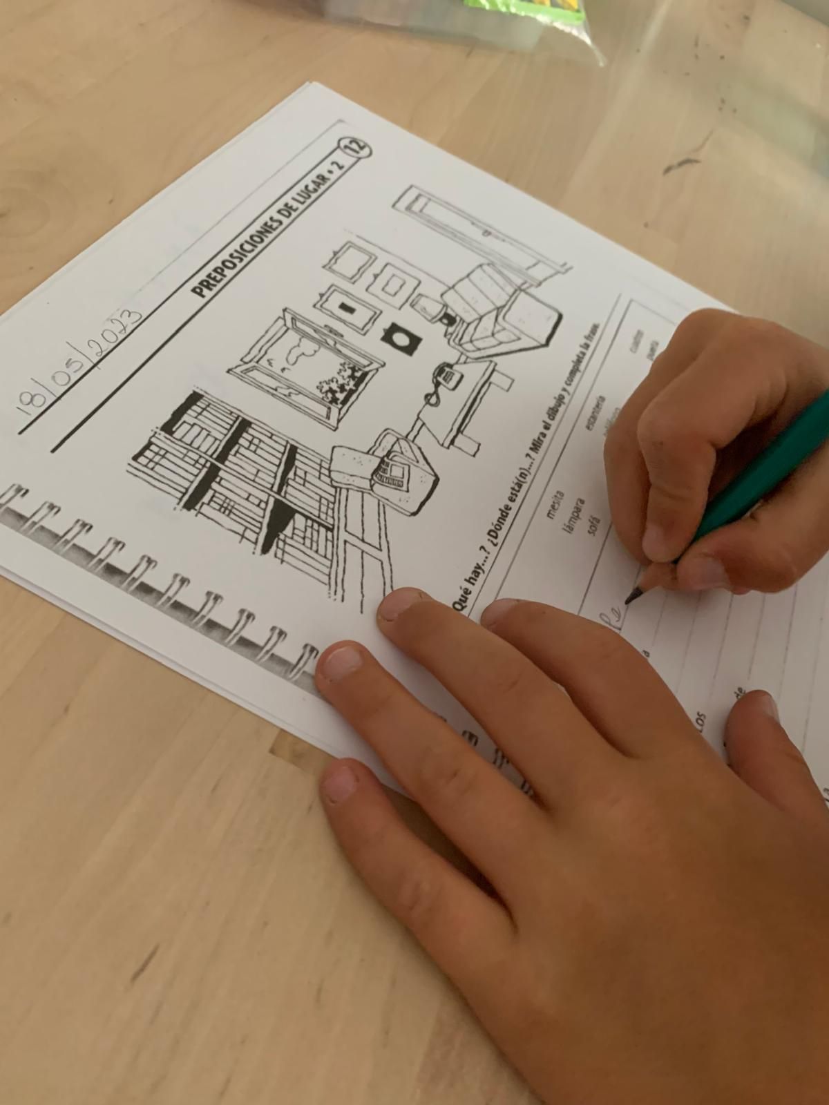 Las manos de un niño escribiendo con un lápiz en una hoja de trabajo, dibujo de diseño de interiores.