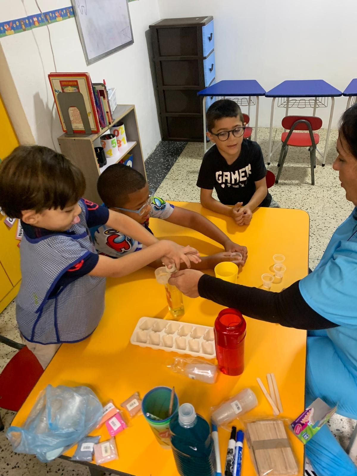 Niños en un aula realizando un experimento científico con un instructor.