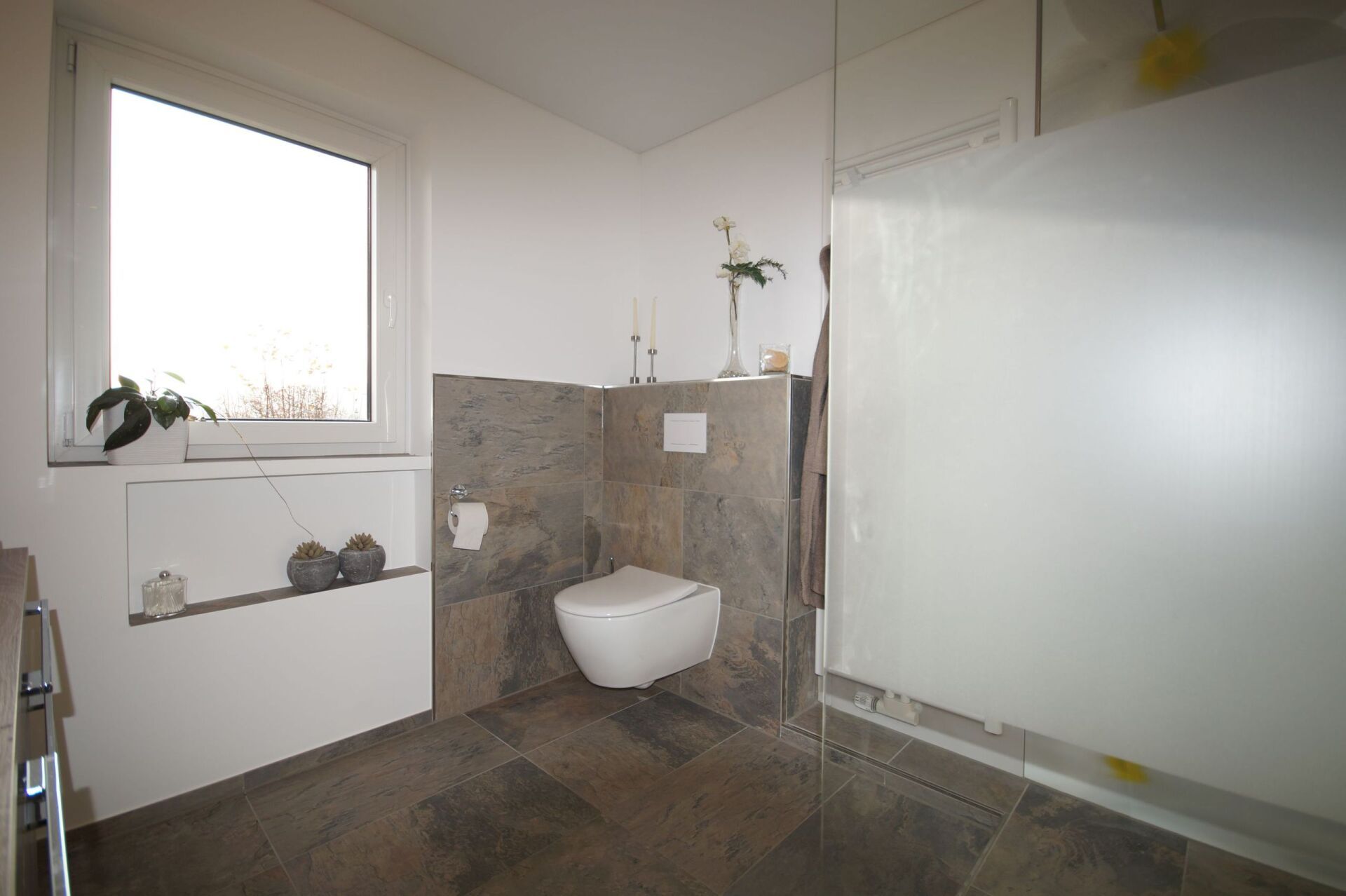 sehr großes Badzimmer mit weißer Toilette