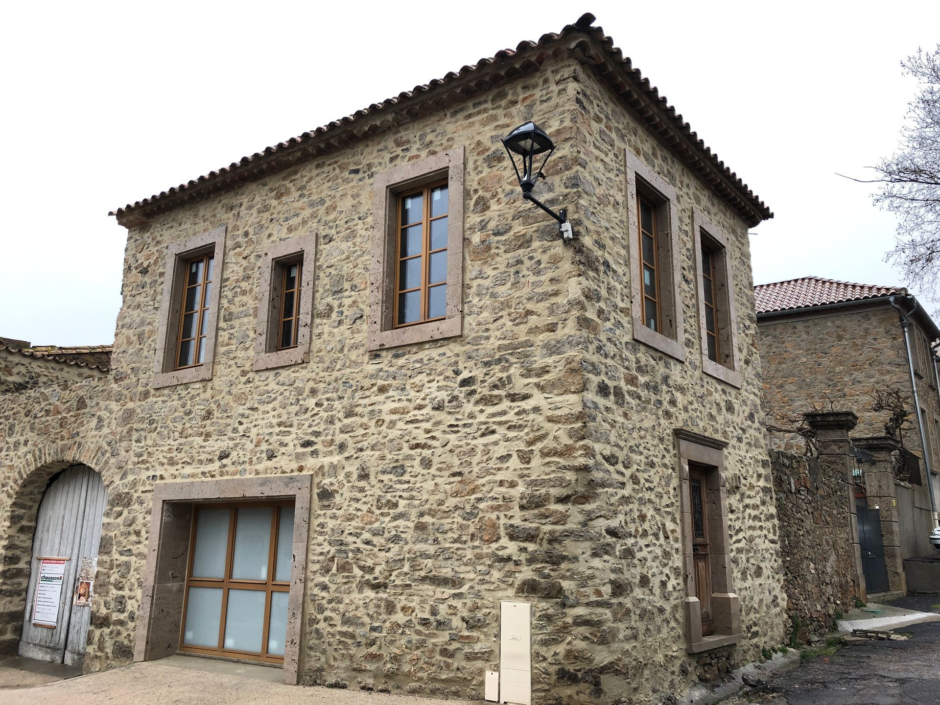 Une maison avec façade en pierres et menuiseries en bois