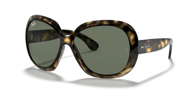 Un par de gafas de sol con montura con estampado de leopardo y lentes verdes sobre una superficie blanca.