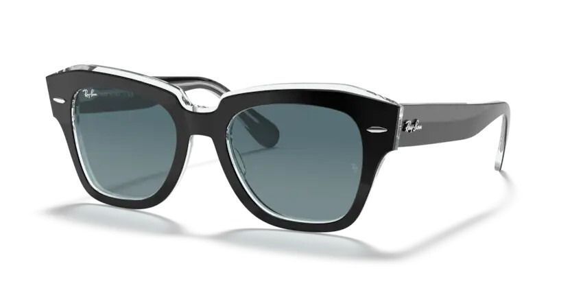 Un par de gafas de sol Ray-Ban están sobre una superficie blanca.
