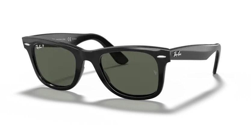 Un par de gafas de sol Ray-Ban Wayfarer están sobre una superficie blanca.