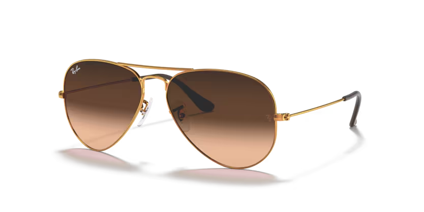 Un par de gafas de sol de aviador Ray-Ban con lentes rosas sobre fondo blanco.