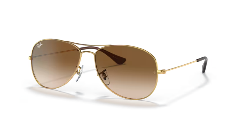 Un par de gafas de sol de aviador Ray-Ban con lentes azules sobre fondo blanco.