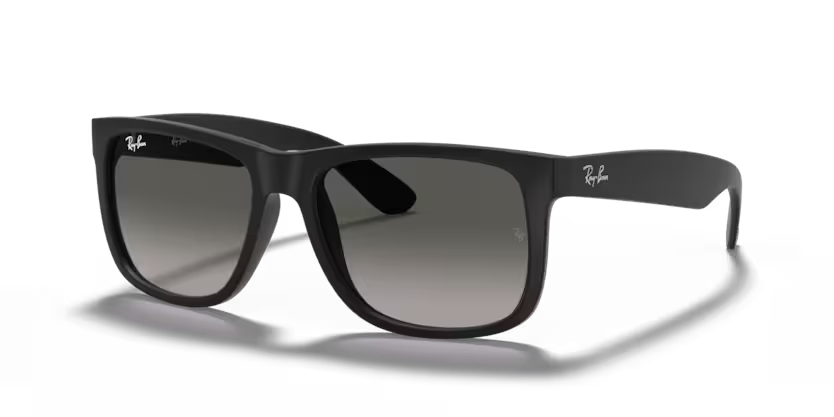 Un par de gafas de sol Ray-Ban negras están sobre una superficie blanca.