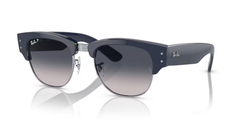 Un par de gafas de sol de aviador Ray-Ban con lentes verdes sobre fondo blanco.