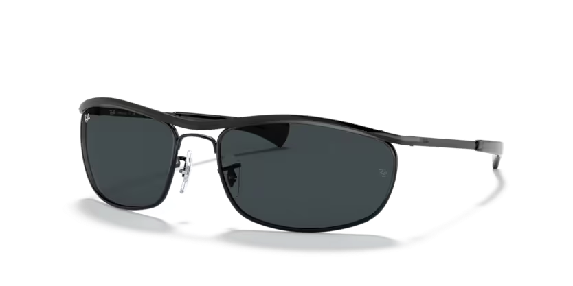 Un par de gafas de sol Ray-Ban negras están sobre una superficie blanca.