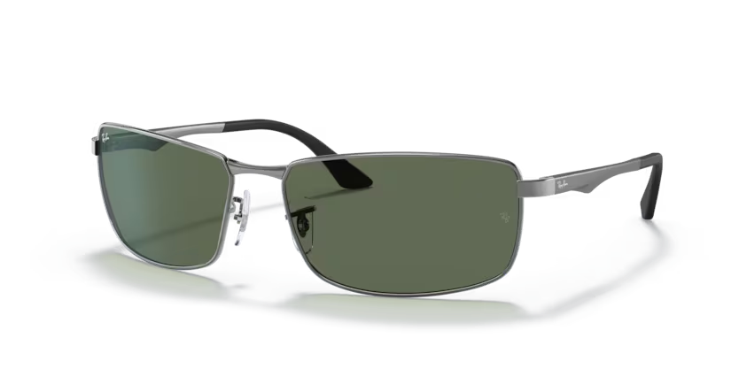 Un par de gafas de sol de aviador Ray-Ban con lentes verdes sobre fondo blanco.