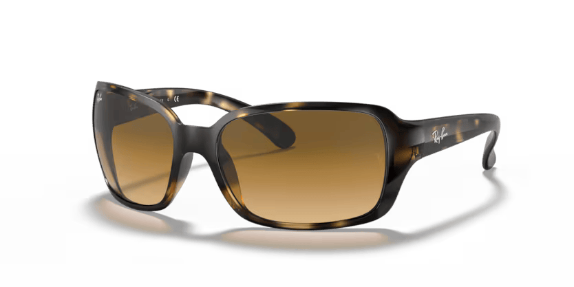 Un par de gafas de sol Ray-Ban están sobre una superficie blanca.