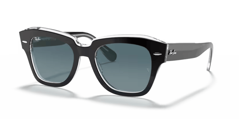 Un par de gafas de sol de aviador Ray-Ban con lentes verdes sobre fondo blanco.