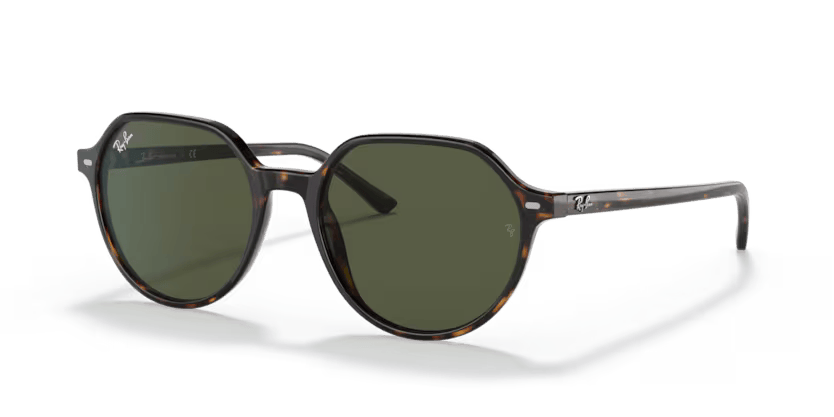 Un par de gafas de sol de aviador Ray-Ban con lentes rosas sobre fondo blanco.