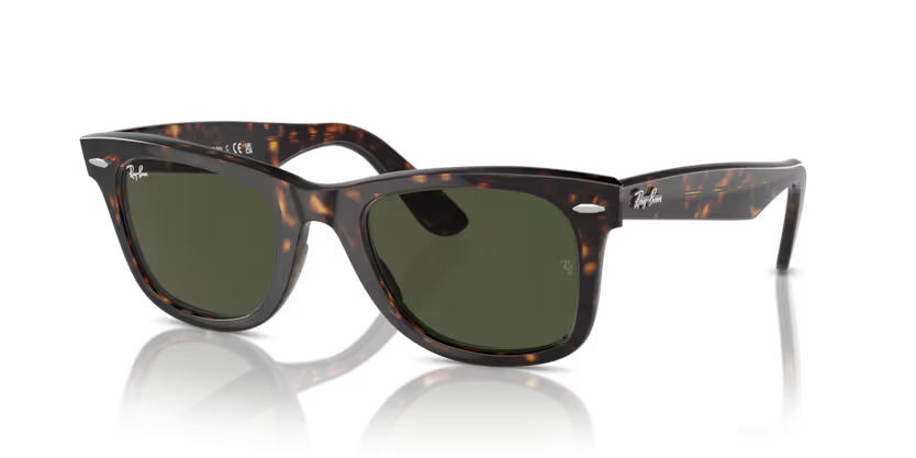Un par de gafas de sol de aviador Ray-Ban con lentes verdes sobre fondo blanco.
