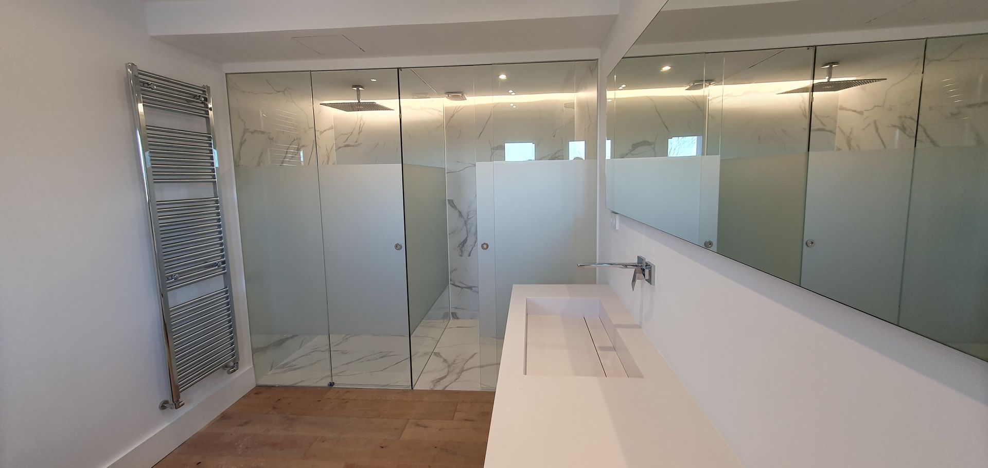 Un baño con lavabo, ducha y espejo.