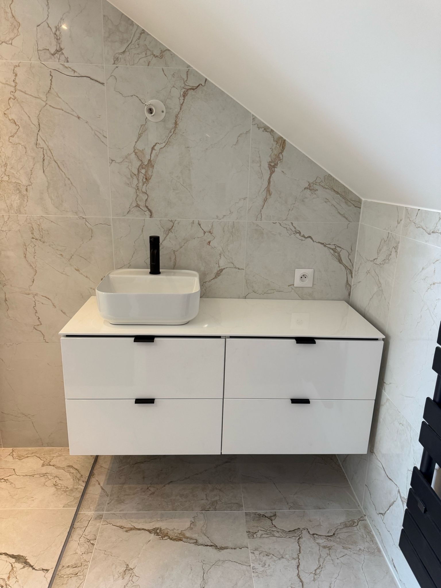 Meuble de salle de bain avec un lavabo blanc et une crédence en marbre