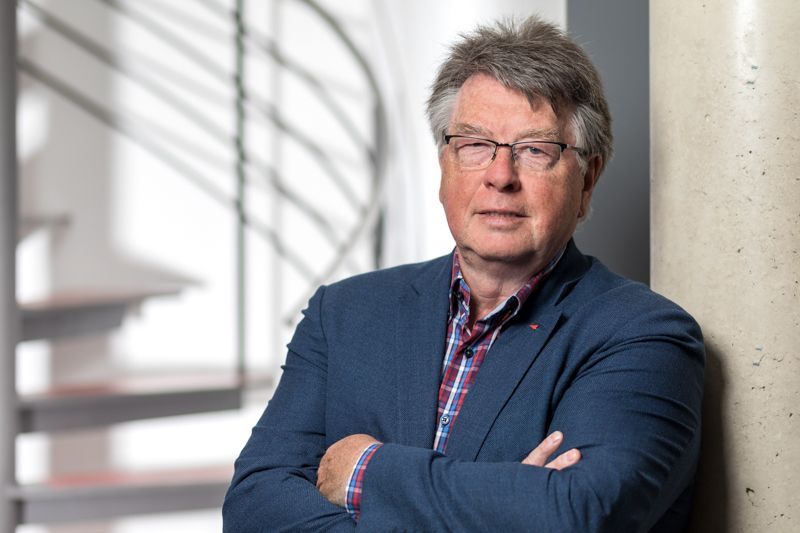 Ein Mann lehnt mit verschränkten Armen an einer Wand