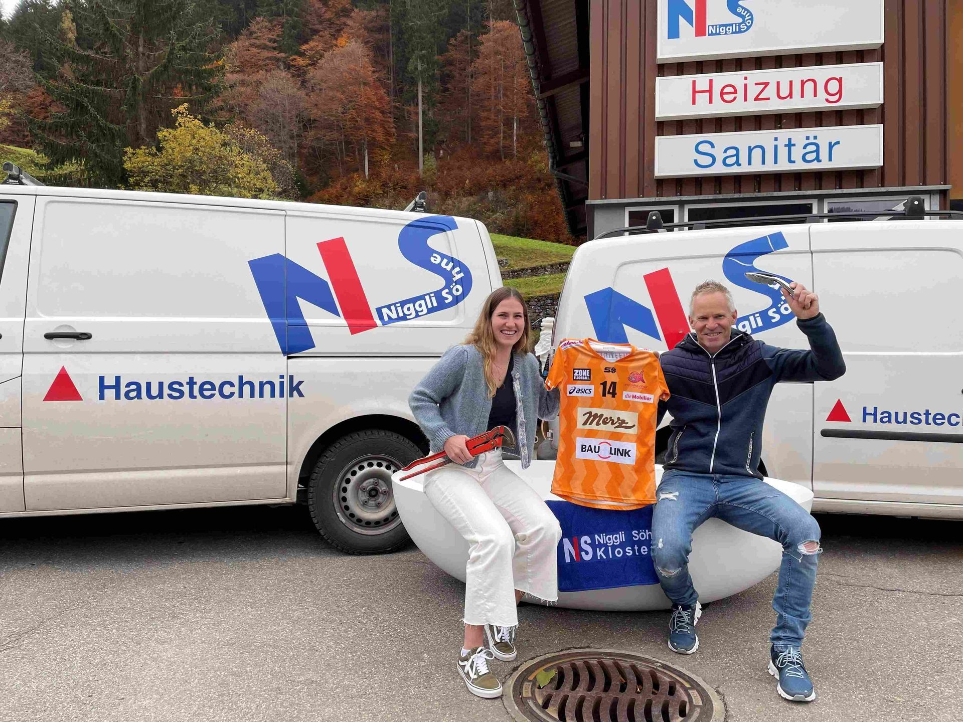 Mann und Frau mit Unihockey Trikot vor vor Betriebsauto der Firma Niggli Söhne Haustechnik AG