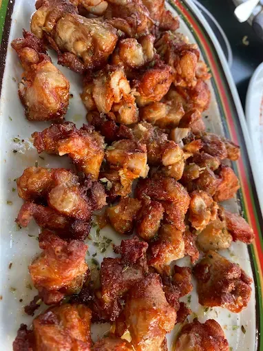 Plato de trozos de pollo frito, dorados y crujientes.