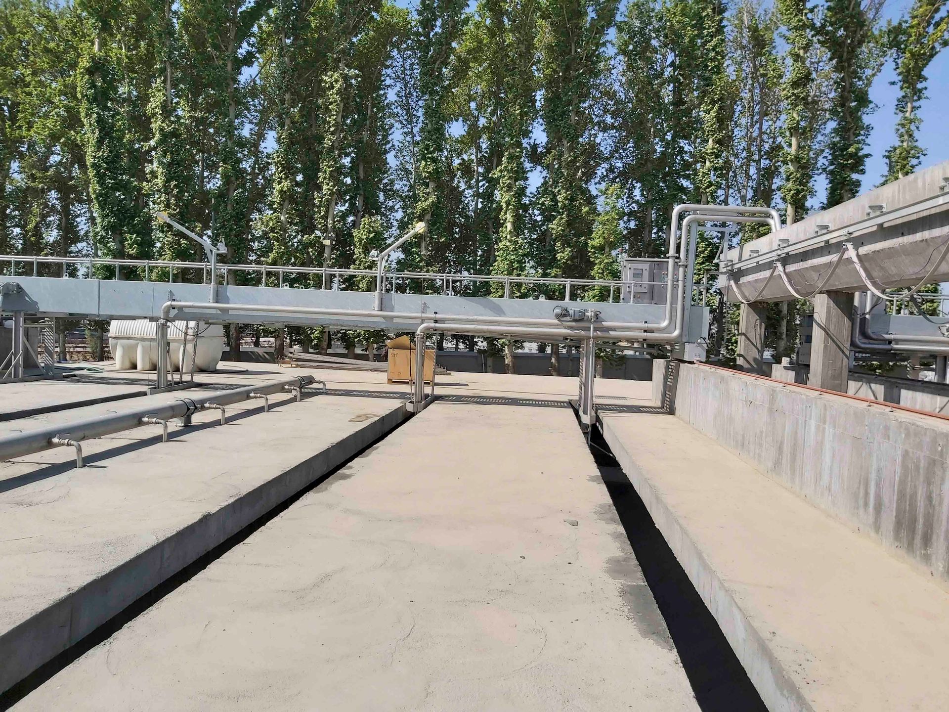 Eine große Betonkonstruktion mit vielen Rohren und Bäumen im Hintergrund.