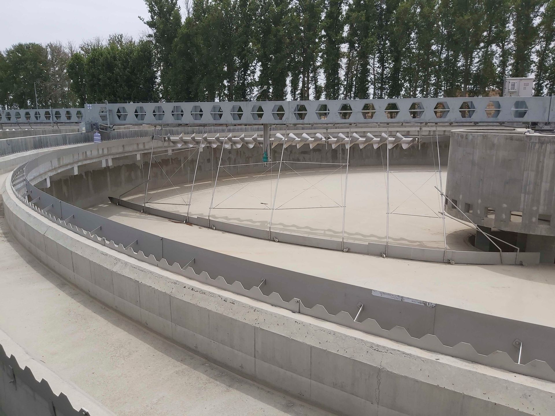 Eine große kreisförmige Betonkonstruktion mit Bäumen im Hintergrund