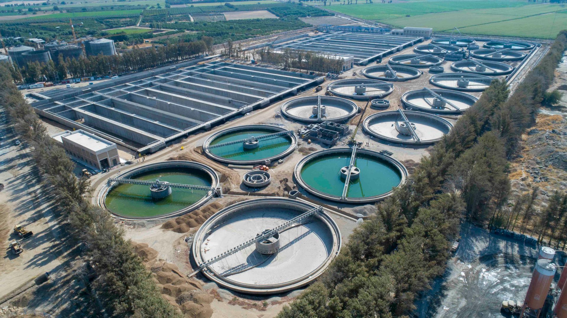 Eine Luftaufnahme einer großen Wasseraufbereitungsanlage, umgeben von Bäumen.
