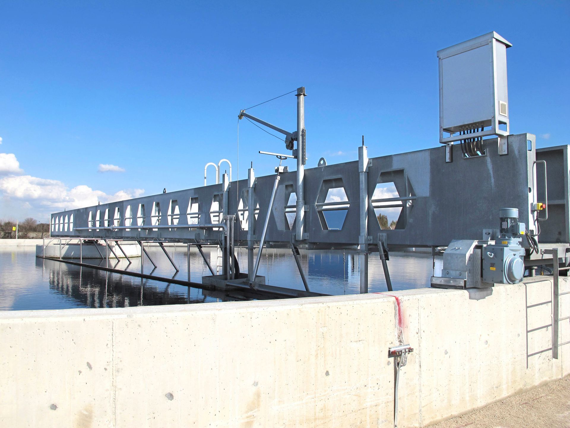 Neben einem Gewässer steht eine große Betonkonstruktion.