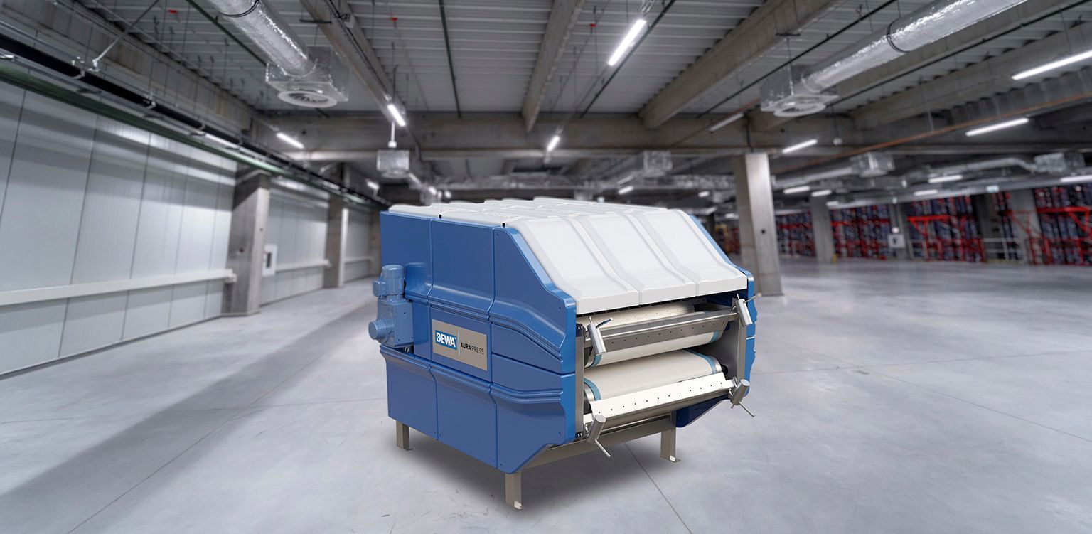 In einer leeren Lagerhalle steht eine blau-weiße Maschine.