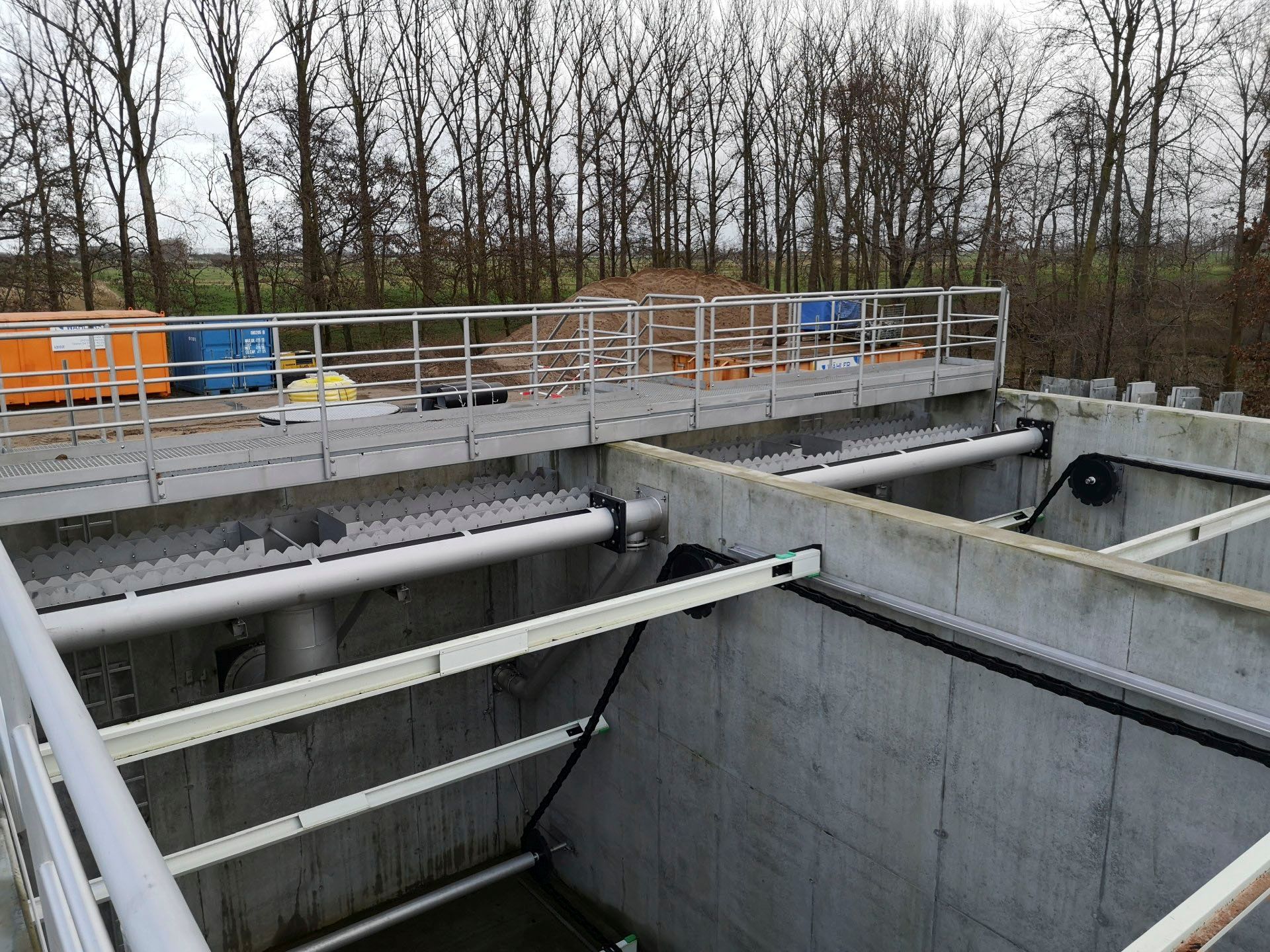 Eine Betonkonstruktion mit einem Metallgeländer und Bäumen im Hintergrund