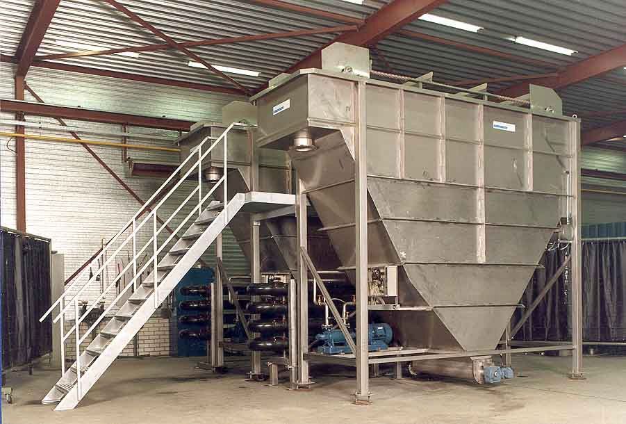 Ein großer Edelstahltank mit einer Treppe, die in einer Lagerhalle nach oben führt.