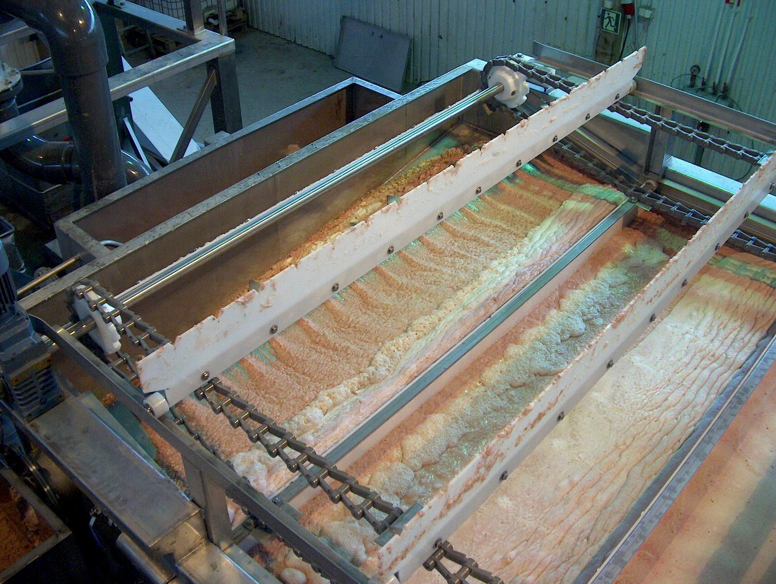 In einer Fabrik steht eine Maschine auf einem Holztisch.