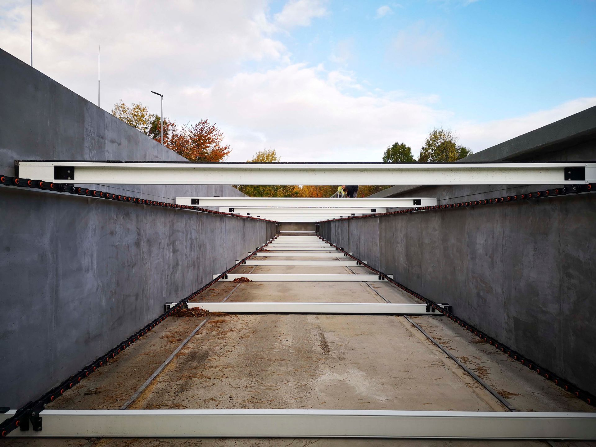 Ein Betonweg mit einem weißen Geländer und einem blauen Himmel im Hintergrund