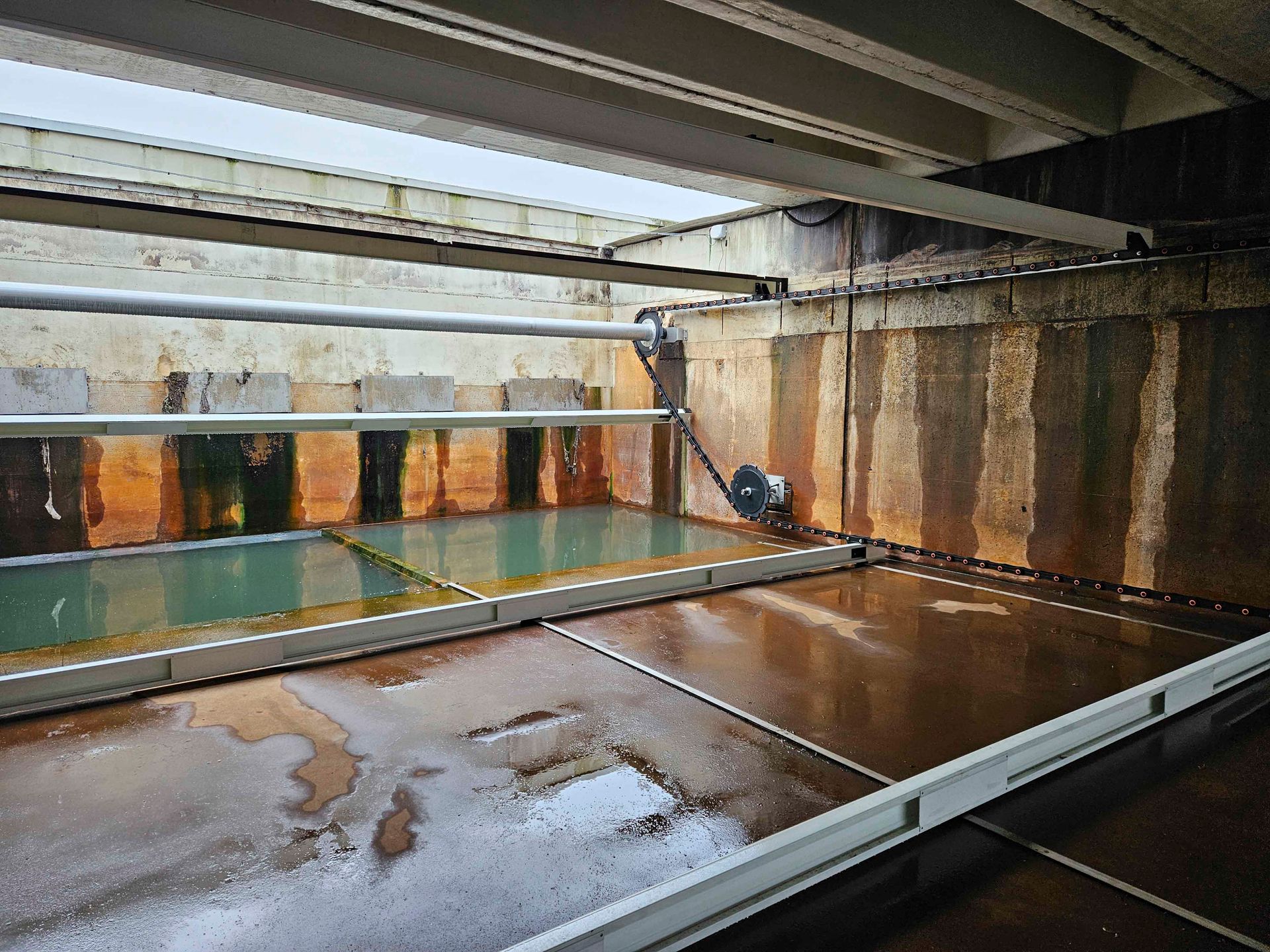 Ein großer Raum mit vielen Rohren und Wasser darin.