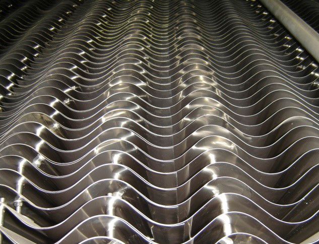 Eine Nahaufnahme einer Metalloberfläche mit einem Wellenmuster