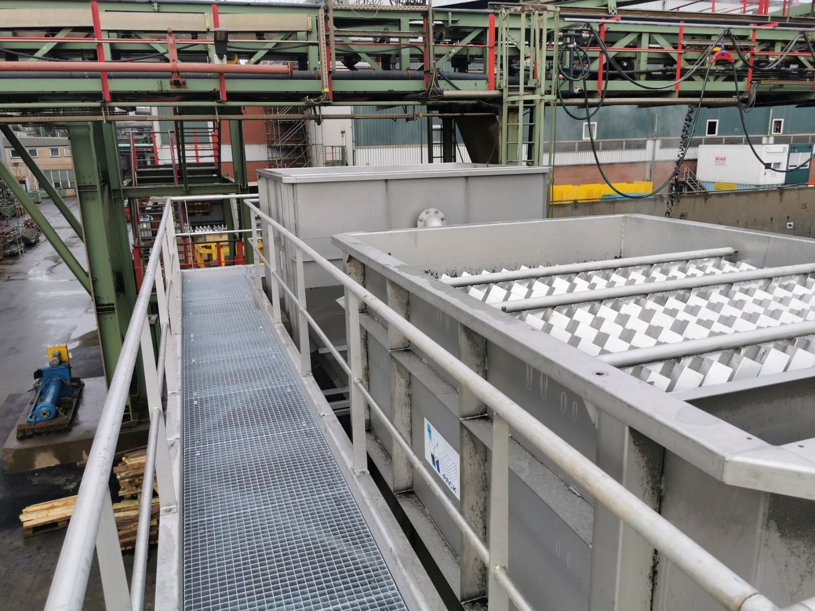 Ein Metallsteg, der zu einem Metallcontainer in einer Fabrik führt