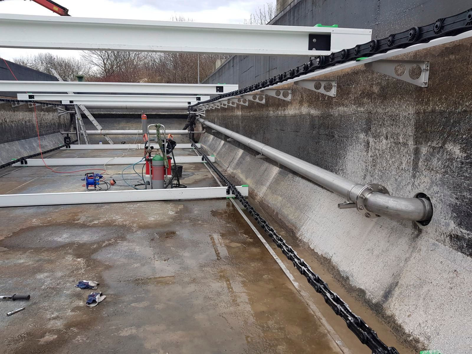Eine Betonwand, an der ein Metallrohr befestigt ist.