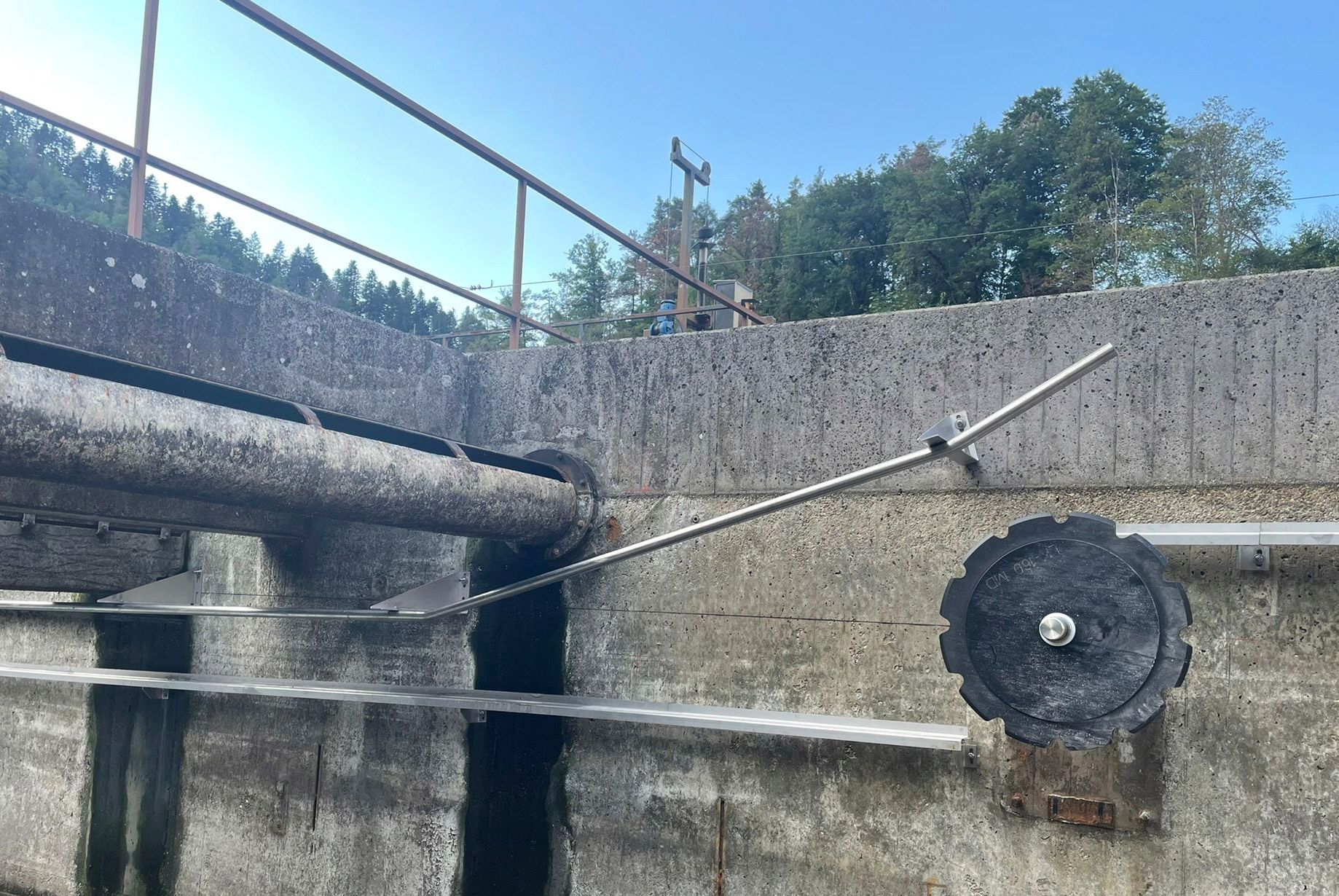 Eine Betonwand mit einem Rohr und einem runden Gegenstand darauf.