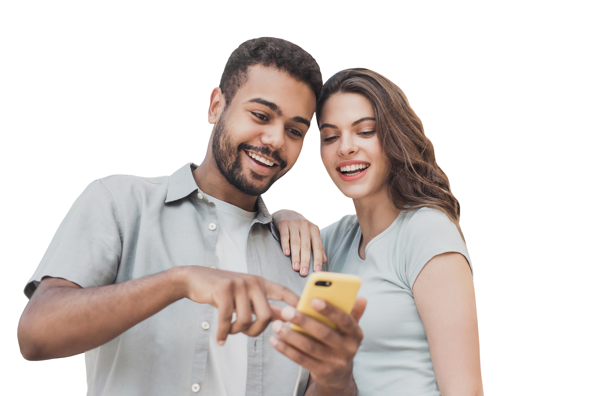 Un homme et une femme regardent un téléphone en souriant. L'homme désigne l'écran. En extérieur.