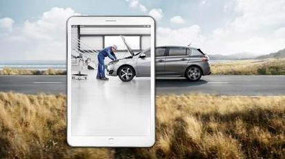 Pantalla de una tableta que muestra un coche en el taller, con un SUV al fondo.