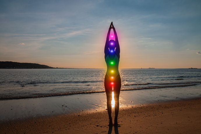 Une femme fait du yoga face à la mer