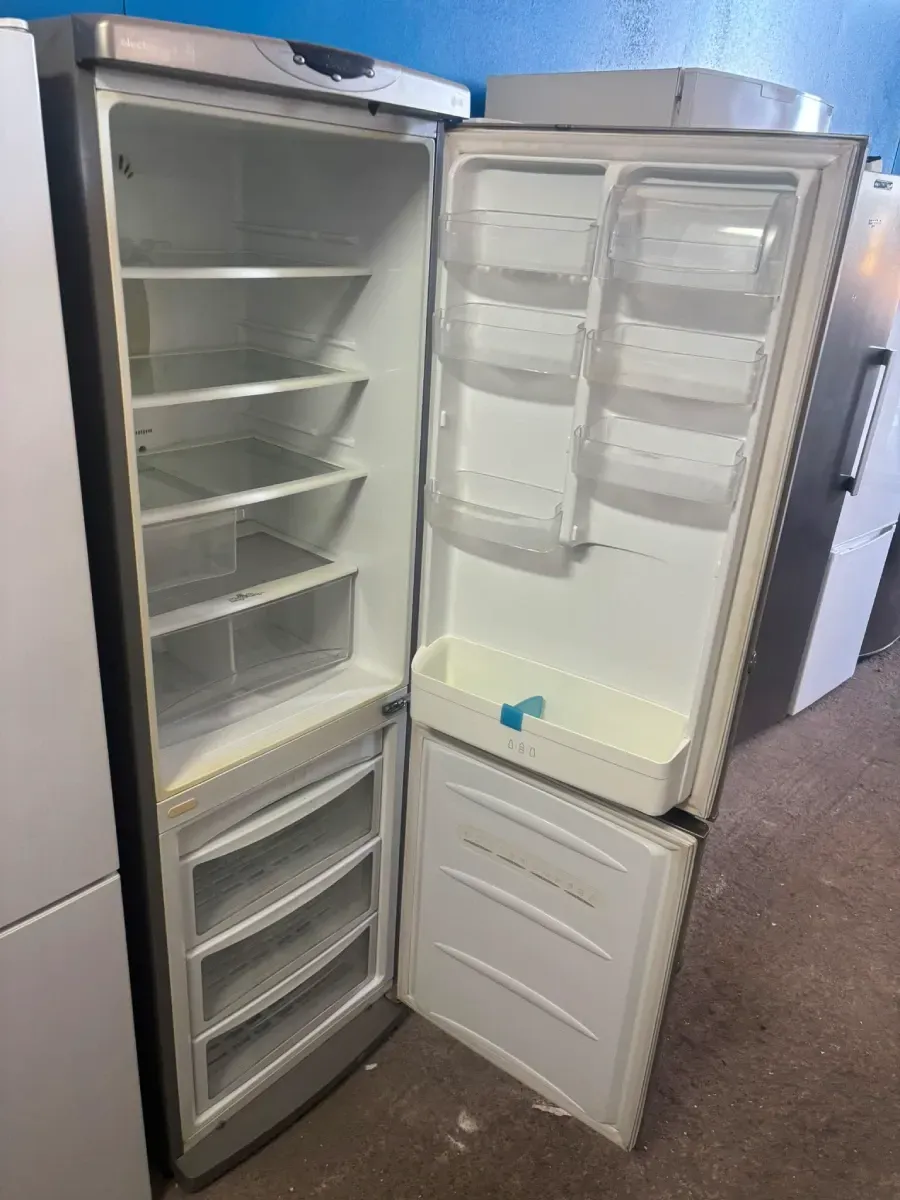 Refrigerador abierto con estantes y compartimentos de la puerta vacíos, visto desde el frente.