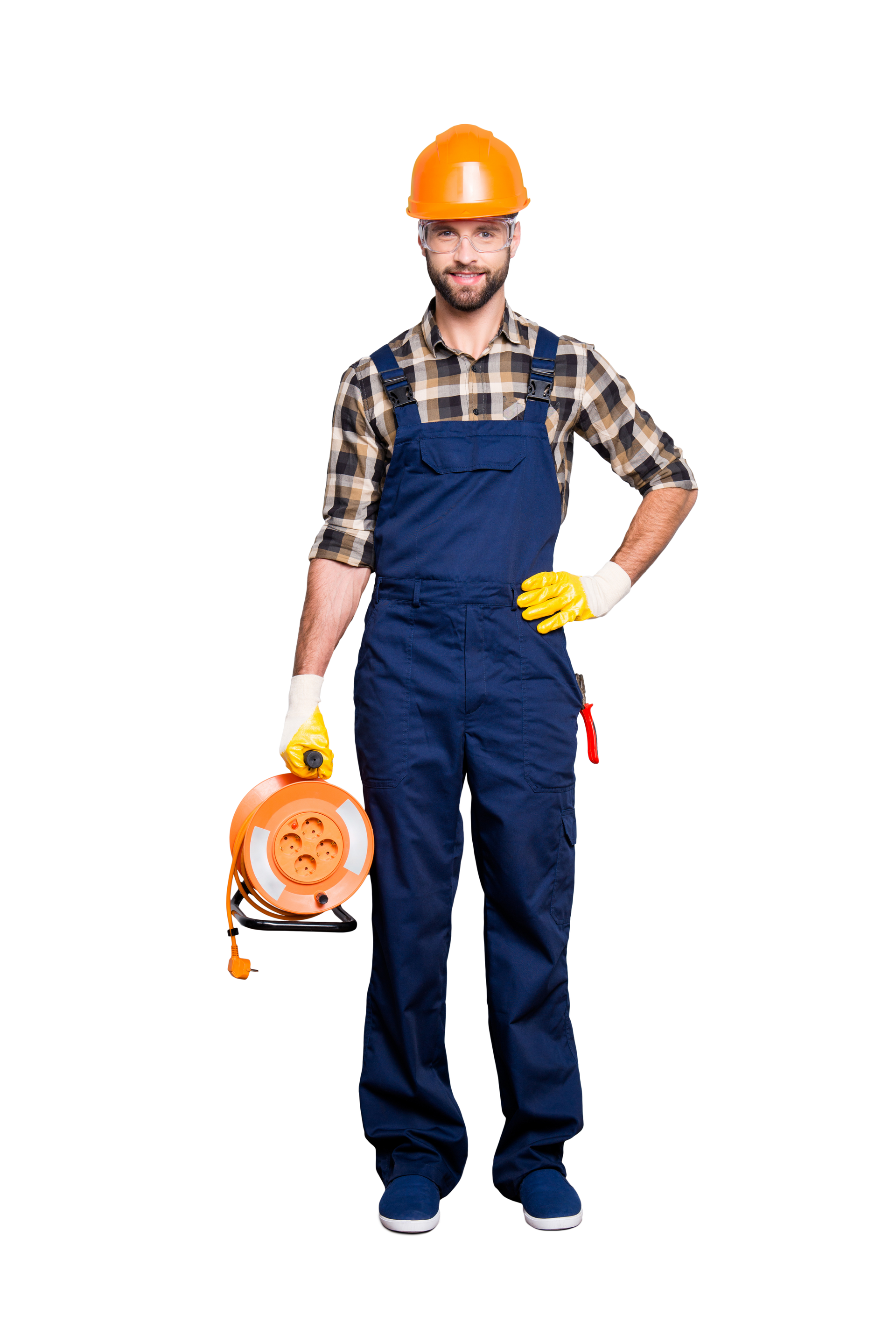 Un électricien en salopette bleue avec un casque de chantier tient un enrouleur de rallonge électrique orange.
