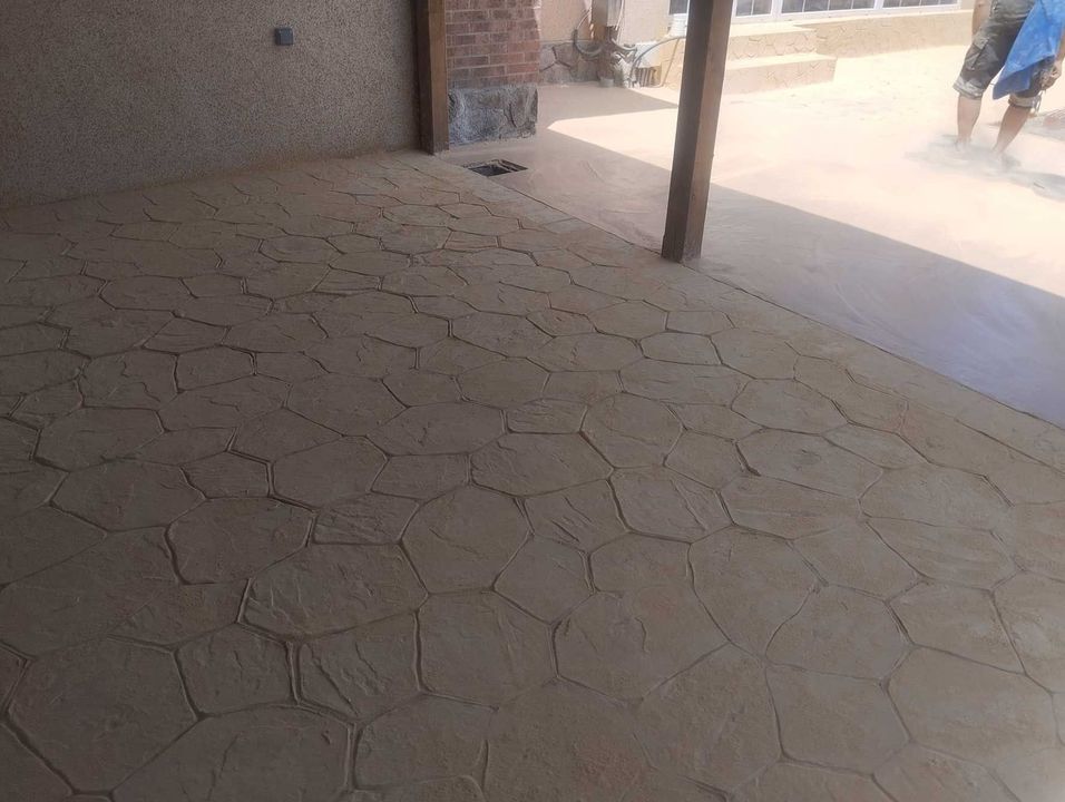 Una persona está parada sobre un piso de concreto debajo de un área cubierta.
