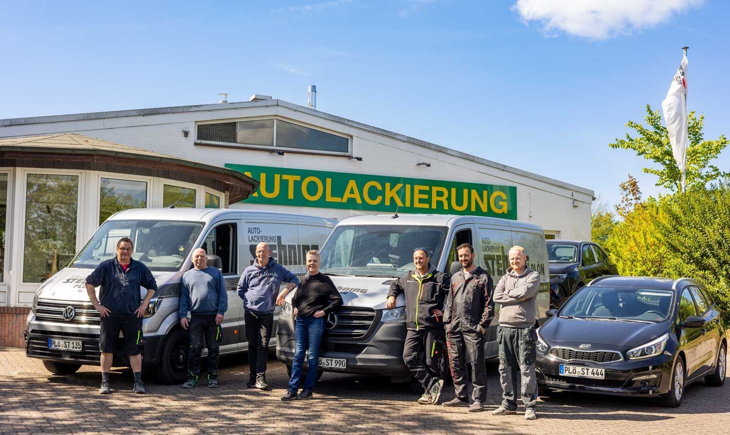 Eine Gruppe von Menschen posiert vor einem Gebäude für ein Foto.