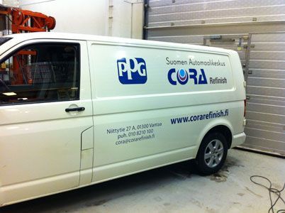 Valkoinen pakettiauto, jossa on PPG, Cora ja yhteystiedot autotallissa.
