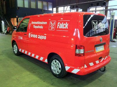 Punainen Falckin huoltoauto, jossa on valkoiset tekstit ja logo, pysäköitynä sisätiloihin.