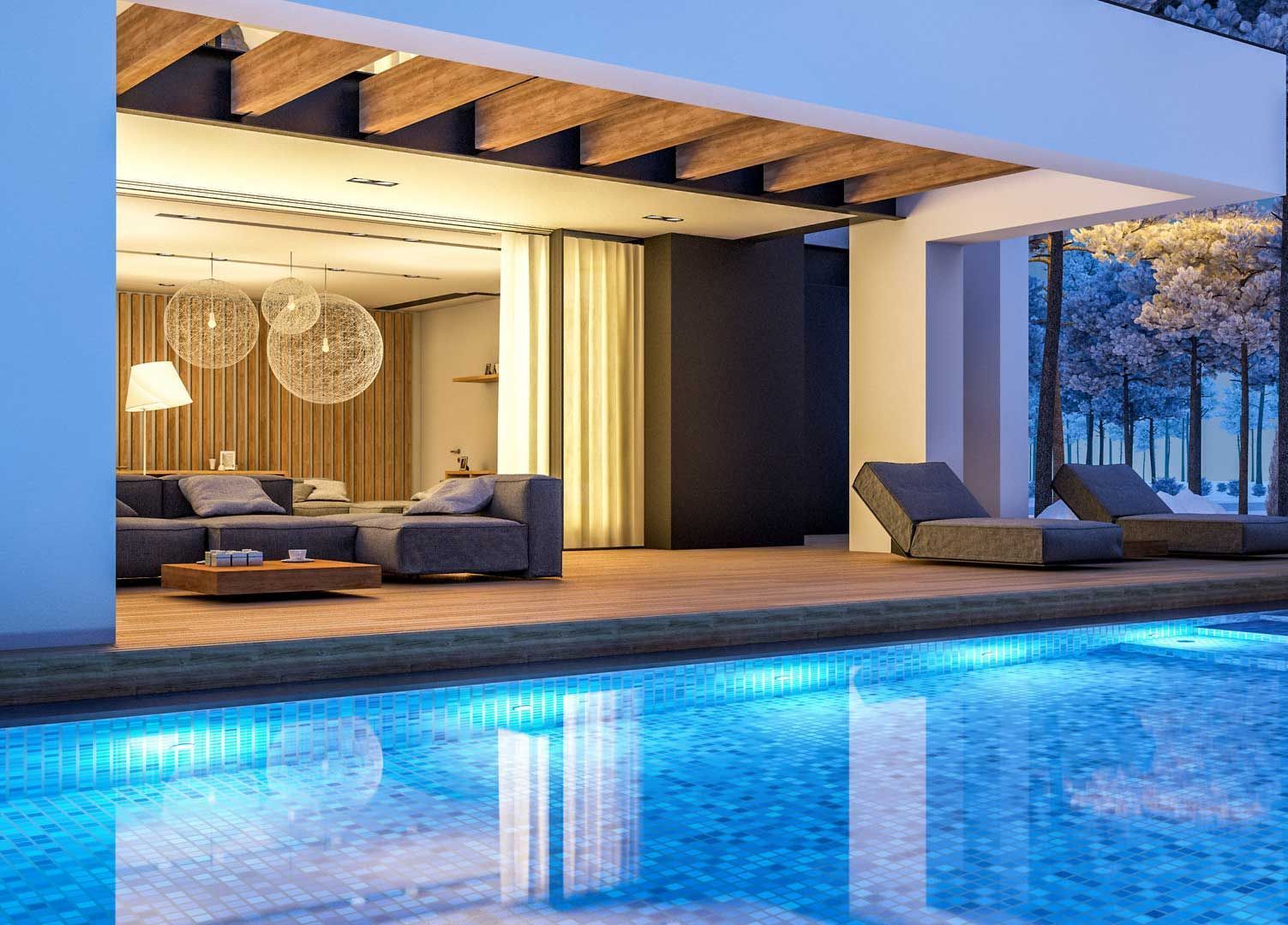Patio moderno de lujo con piscina iluminada en azul, tumbonas y terraza cubierta al atardecer.